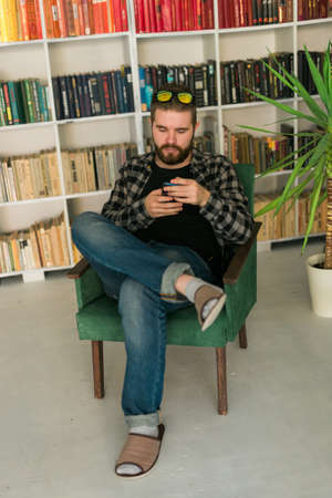 Attractive smiling hipster man relaxing at home. Gen Z and millennial generation concept.