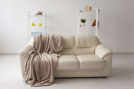 Beige sofa against white empty wall in simple living room interior. Minimalism concept.の写真素材