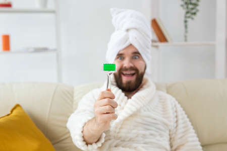 Funny man with facial massage tool. Male skin care and spa concept.の写真素材