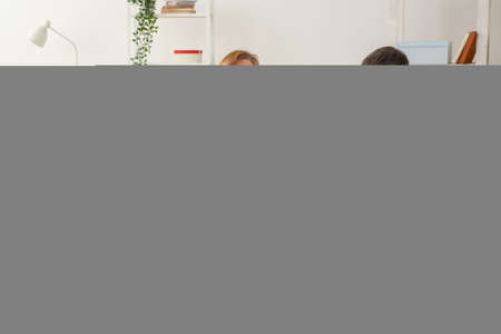 Family sitting on sofa in their living room. Daughter have injury hand but she is happy be together her family.の写真素材