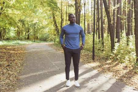 African american student walking in the park in autumn seasonの写真素材