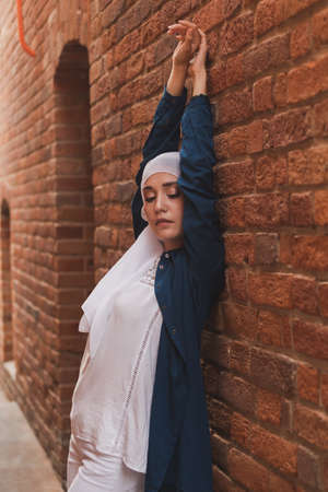Modern muslim girl fashion with hijab.Beautiful Muslim female model wearing hijab and casual outfit posing on urban backgroundの写真素材