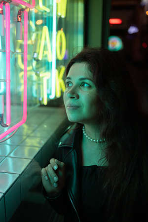 Cinematic night portrait of girl and neon lights in city - night life and youth concept