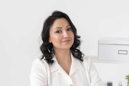 Successful young woman cosmetologist or doctor on background beauty office. Portrait of professional beauticianの写真素材