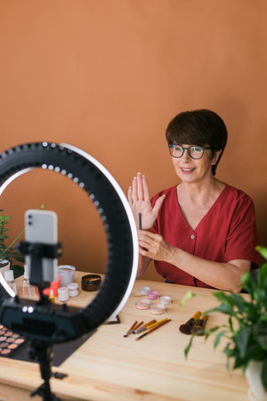Beauty and cosmetics e-commerce and blogging concept - professional mature female make up artist...
