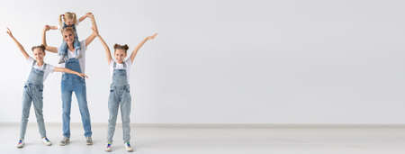 Banner family and children concept - twin sisters and baby girl with their mom on white background...