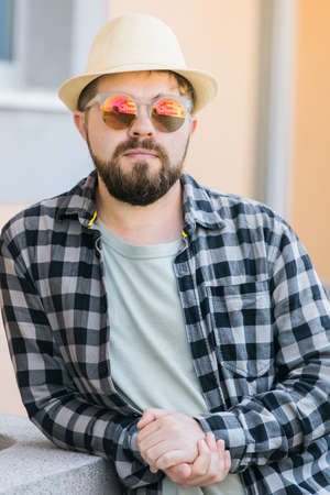 Close up portrait handsome man wearing sunglasses over urban background - travel vacations and...