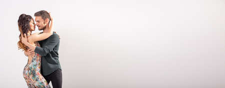 Skillful dancers performing in white background banner with copy space. Sensual couple performing an artistic and emotional contemporary dance bachata or kizomba or salsaの写真素材
