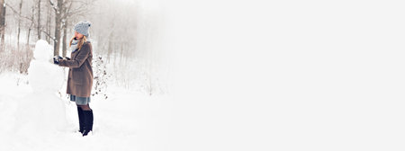 Banner woman making a snowman in winter time copy space and christmas timeの写真素材