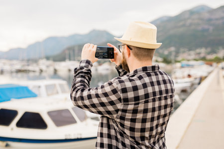 Traveller man taking pictures of luxury yachts marine during sunny day - travel and summer conceptの写真素材