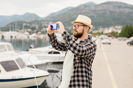 Traveller man taking pictures of luxury yachts marine during sunny day - travel and summer conceptの写真素材