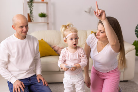 Cochlear implant on the child girl head and playing with mother and father. Hearing aid and deafness and innovative health technology conceptの写真素材