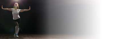 Banner dancing concept - Pretty woman dancing jazz funk over dark background copy spaceの写真素材