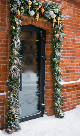 Stylish christmas fir branches with baubles and sparkling garland on front of door at holiday market or restaurant in city street. Winter christmas street decorの写真素材