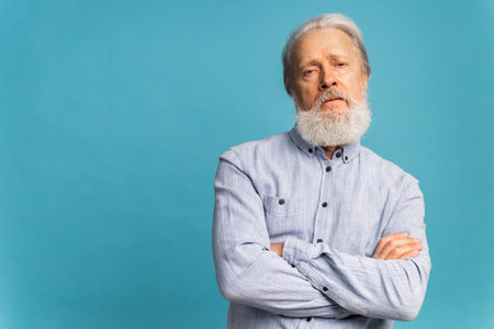 Portrait angry old man white bearded pensioner unhappy mad crazy conflict disagreement over blue...