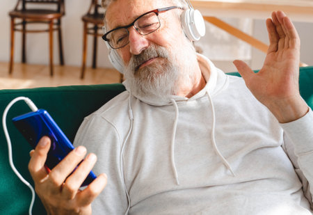 Elderly man cool bearded old man using mobile phone for video call - happiness elderly lifestyle...