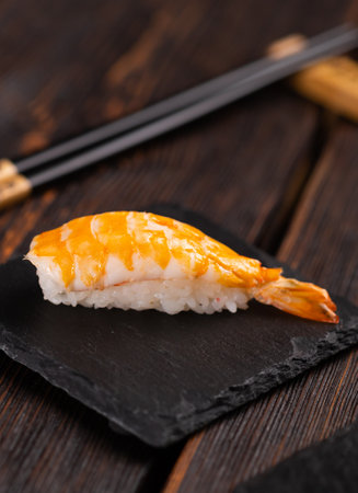 Japanese seafood sushi nigiri with shrimp on black and wooden background - asian cuisine conceptの写真素材