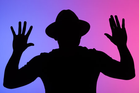 Silhouette of perplexed young african american man his hands up guy on blue and pink neon background...