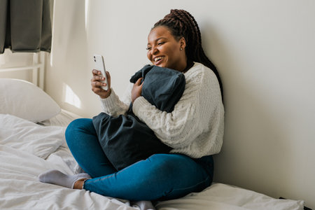 African american woman making video call in bedroom - social networks and connectionの写真素材