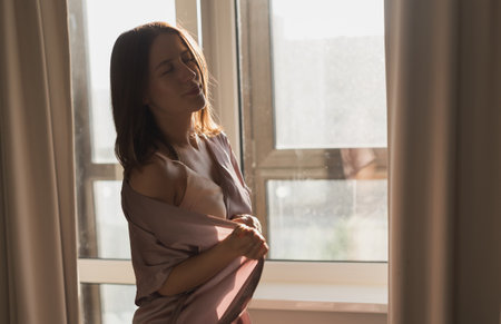Young woman enjoying sunny morning on bedroom copy space and empty space for text - wake-up and wellness conceptの写真素材