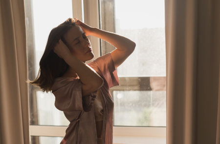 Young woman enjoying sunny morning on bedroom copy space and empty space for text - wake-up and wellness conceptの写真素材