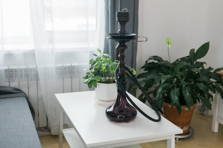 Shisha hookah bowl with red hot coals and craft tobacco. Modern hookah with coconut charcoal for...