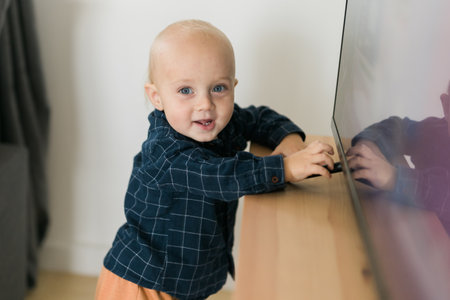 Caucasian baby newborn infant making first steps. Cute toddler kid child son boy learning walking creeping on living room. Childcare and childhood conceptの写真素材
