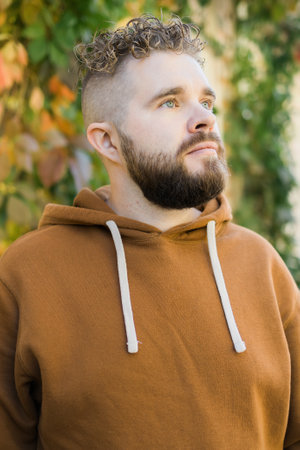 Outdoor portrait of young handsome smiling curly hair style man with beard in spring seasonの写真素材