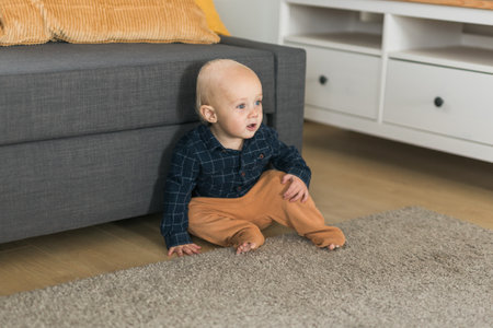 Nursery baby boy crawling on floor indoors at home copy space and empty space for text - Baby...