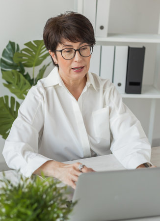 Businesswoman working in office doing video call with laptop. Female professional making videocallの写真素材