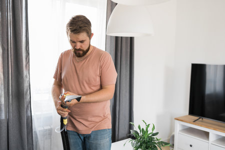 Man dry cleaners employee hand in protective rubber glove cleaning sofa with professionally extraction method. Early spring regular cleanup. Commercial cleaning company conceptの写真素材