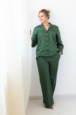 Glamorous woman wears pajama with happy smile chilling in good morning. Positive female model homewear and free time holidays at home conceptの写真素材