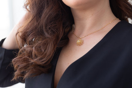 Elegant woman wearing luxury pendant and gold necklaces - jewellery and accessories concept