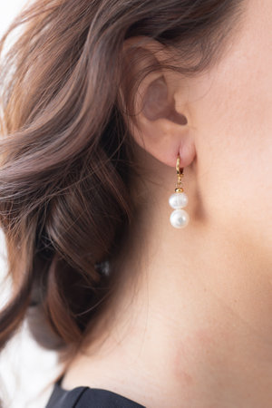 Glamour and beauty, jewelry and luxury concept - close up of beautiful woman face with pearl earringの写真素材