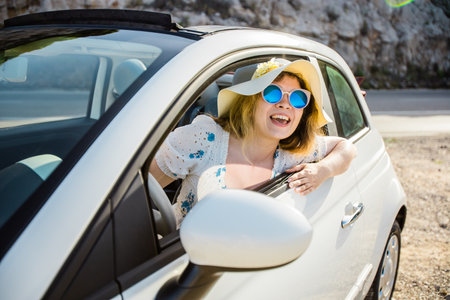 Young woman drive and having fun in cabrio against mountains - travel and summer voyage nature...
