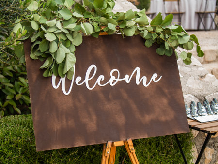 Plaque with inscription greeting guests at wedding. Welcome inscription sign wedding decorations. Wedding decor outdoor marriageの写真素材