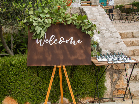 Plaque with inscription greeting guests at wedding. Welcome inscription sign wedding decorations. Wedding decor outdoor marriageの写真素材