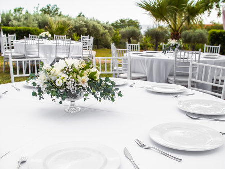 Table at luxury wedding reception event. Beautiful flowers on table and serving dishes and glasses...