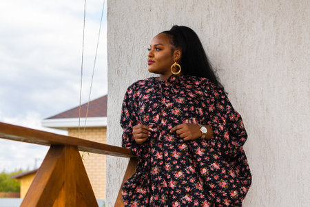 Beautiful african american woman enjoying evening on village and nature on terrace of country house. Diversity and inclusion and cottagecore conceptの写真素材