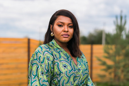 Summer portrait of beautiful african american woman in colourful dress wear standing on backyard....
