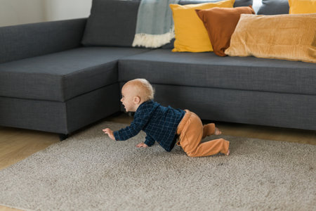 Nursery baby boy crawling on floor indoors at home copy space and empty space for text - Baby curiosity and child development stagesの写真素材