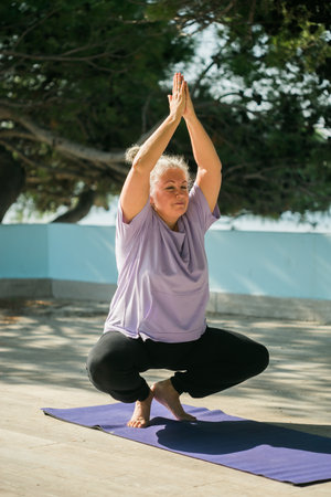 Mature old woman with dreadlocks practicing yoga and tai chi outdoors - wellbeing and wellnessの写真素材