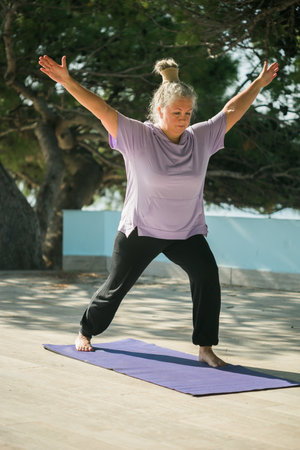 Mature old woman with dreadlocks practicing yoga and tai chi outdoors - wellbeing and wellnessの写真素材
