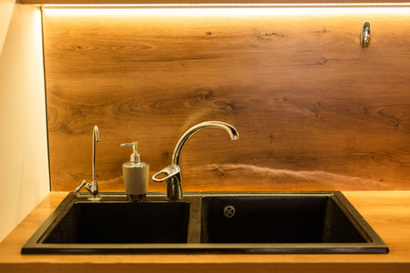 Modern black kitchen sink in kitchen. Interior of kitchen room of apartment. Built-In Appliances. Kitchen Appliance. Domestic Appliancesの写真素材