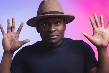Perplexed young african american man his hands up guy on blue and pink neon background studio...