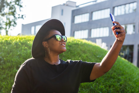 Attractive African woman taking selfie on the street wearing glasses - millennial and generation z conceptの写真素材