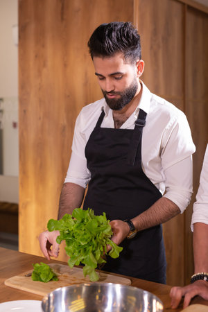 Cook adding some parsley to dish. Chef preparing food and meal cut herbs in a blender in kitchen, chef cookingの写真素材