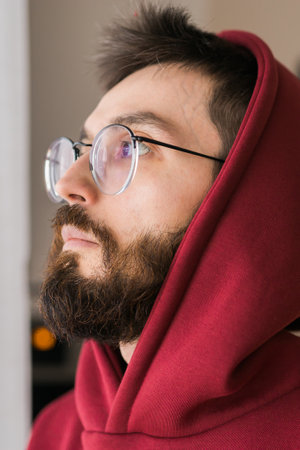 Side view of man longing and looking through window in sad day - depression and melancholy conceptの写真素材