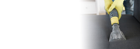 Man dry cleaners employee hand in protective rubber glove cleaning sofa with professionally extraction method. Early spring regular cleanup. Commercial cleaning company conceptの写真素材