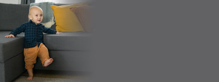 Banner caucasian baby newborn infant making first steps. Cute toddler kid child son boy learning walking creeping on living room copy space. Childcare and childhood conceptの写真素材